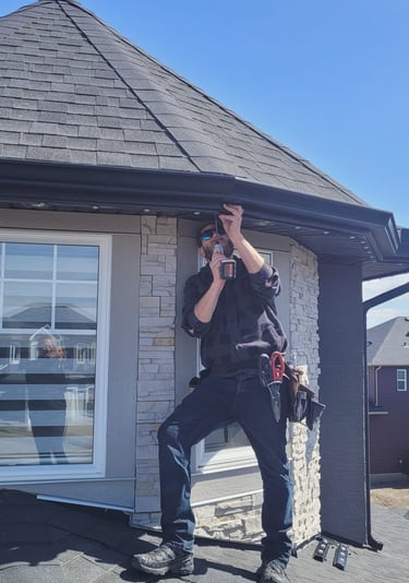 father installing permanent holiday lights on a house in Calgary