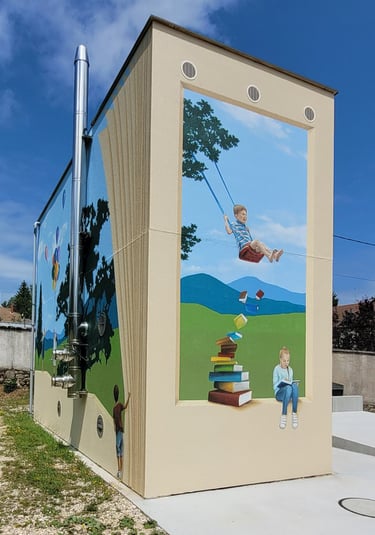 Fresques peintes sur façades. Des pages de livre, des enfants, un paysage simplifié.