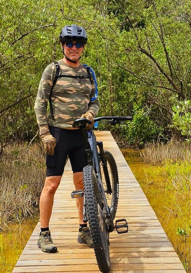 a man riding a bike on a wooden bridge