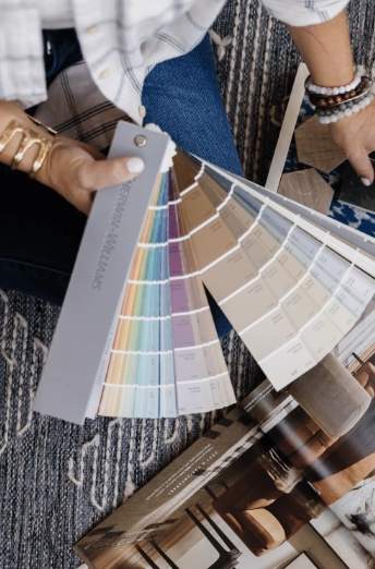 Person holding a paint color sample fan deck.