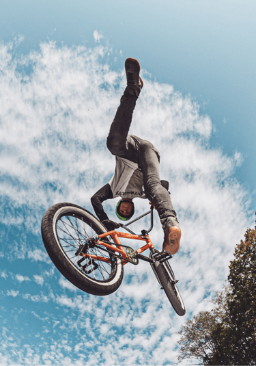 a man doing tricks on a bicycle in the air