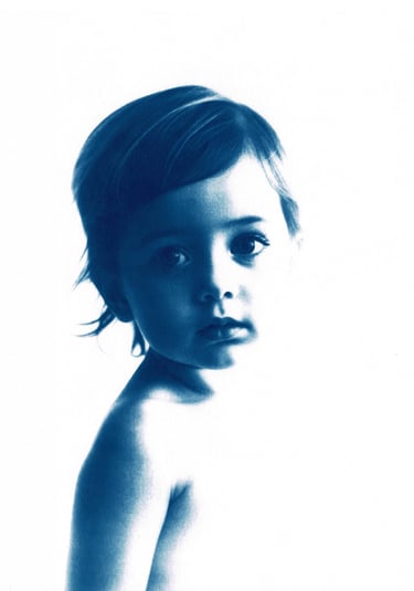 Monochromatic blue portrait of a little girl with short, tousled hair, expressive eyes, and a serene