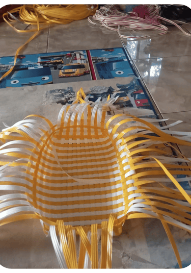 Base structure of a handmade woven bag using natural colored recycled plastic strips at Craftvitas Indonesia.