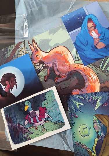 A collection of colorful art prints featuring a red squirrel, a duck, and fantasy character illustrations.
