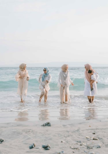 Group of friends walking along the shoreline during photoshoot at Candi Beach Resort Karangasem Bali