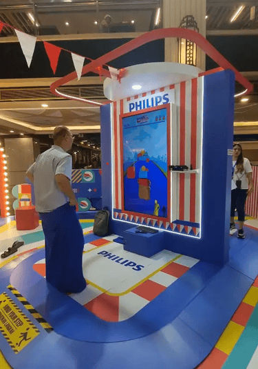 Man playing digital sack race game using Kinect motion sensor at mall activation