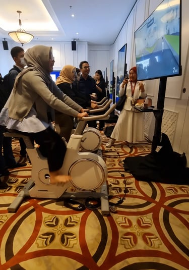Crowd of Mandiri employees playing cycling game at the learning festival