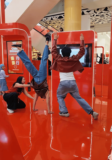 Participant jumping to match the body silhouette in Pocky Hole in the Wall game