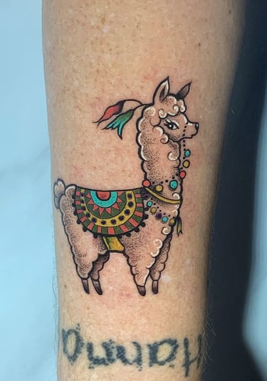 A tattoo style llama tattoo on the arm of a woman's arm. Custom piece by Katarsis Tattoo Perú
