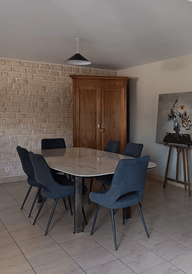 salle à manger avec une table et six chaise, plus une armoire en fond