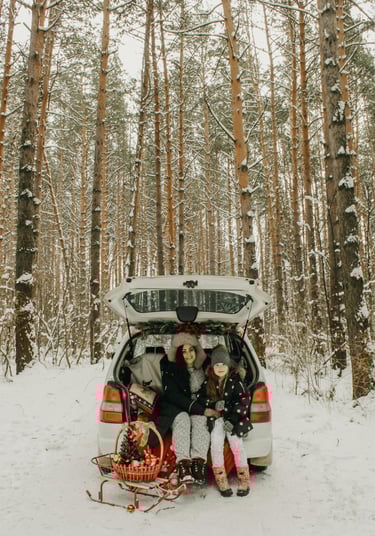 mother and daughter sitting in the trunk of a car