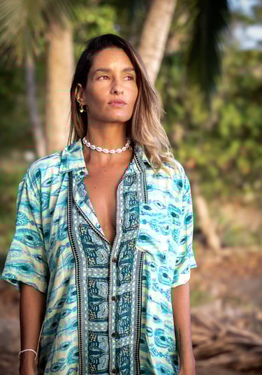 a woman in a blue shirt and a necklace
