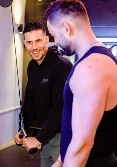 A personal trainer demonstrating an arm exercise to a client