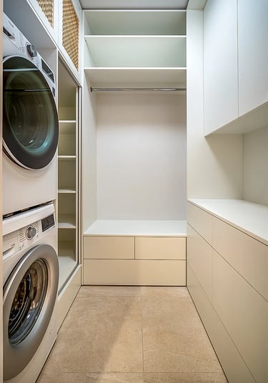 Nowoczesna garderoba z zabudową, półkami i szafkami, drążkiem na ubrania oraz pralką i suszarka