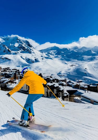 Lifestyle photograph of skiers enjoying a wide, sunny slope in Val Thorens, Europe's highest ski res