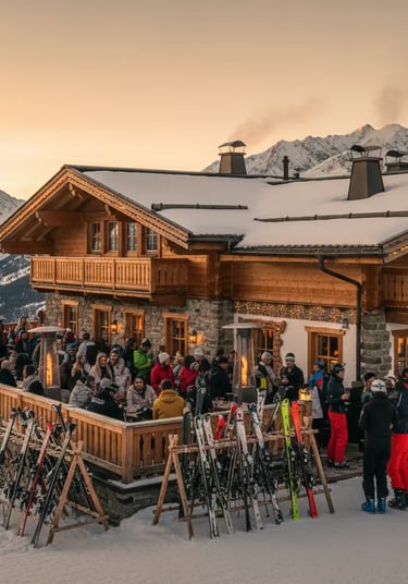 Bustling après ski terrace outside a mountain hut in St. Anton am Arlberg, filled with skiers and sk