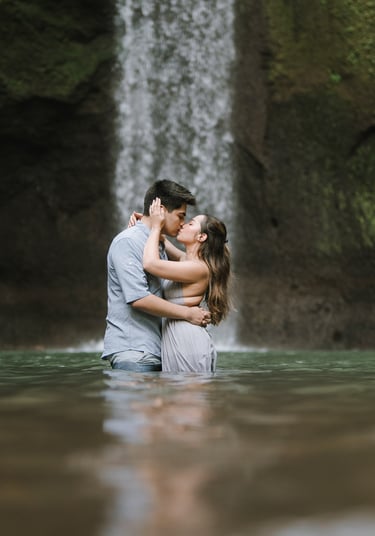 Couple walking in river during prewedding at Tibumana Waterfall Bangli Bali