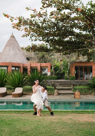 Couple standing by the pool at Waka Gangga Tabanan surrounded by tropical architecture in West Bali