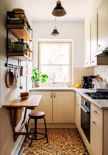 Small kitchen interior with white cabinets, patterned floor tile, and a folding wooden breakfast bar.