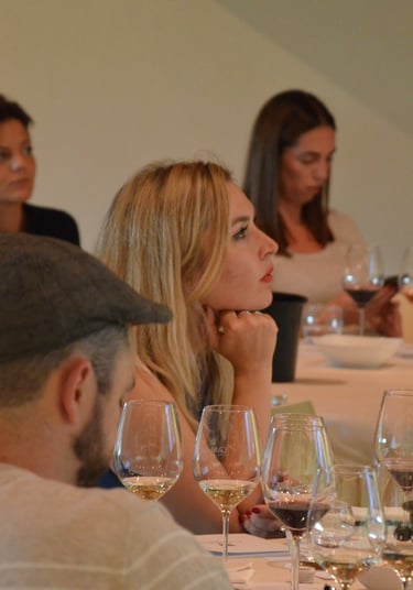 Group of buyers sitting at a table with glasses of wine in front of them