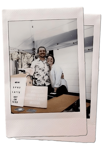 the owners + baristas (tony + sarah) behind their coffee cart and menu
