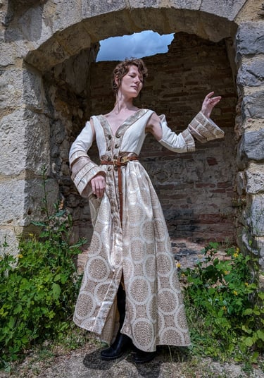 Femme en robe blanche et beige médiévale fantastique dans un fond de château en ruines