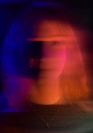 portrait d'une vidéaste avec des jeux de lumière rose et bleu