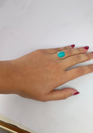 a woman's hand with a turquoise ring on her finger