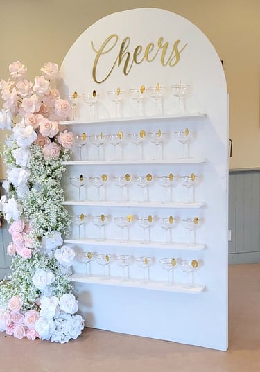 White champagne with a pink and white floral arrangement and champagne flutes