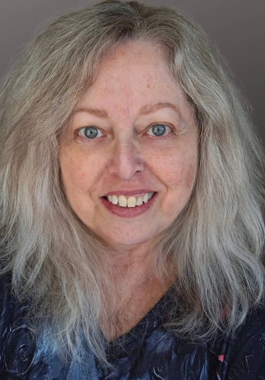 A middle-aged white woman with green eyes and blonde hair