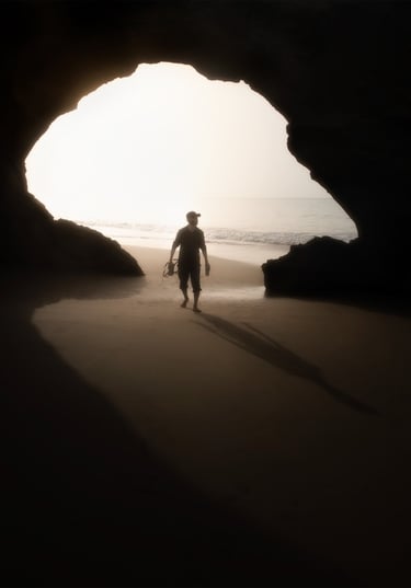 a man walking on the beach with a surfboard . arbab naimat kasi balochistan