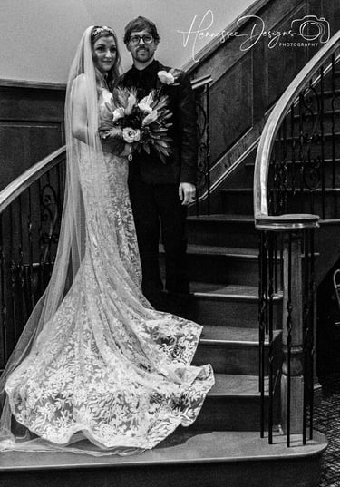 a bride and groom standing on a staircase