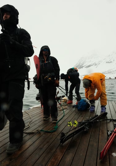 a group of people standing on a dock in Arnøya with skis | ski and sail in Norway