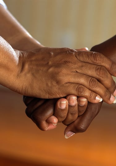 two hands clasping one hand of another person