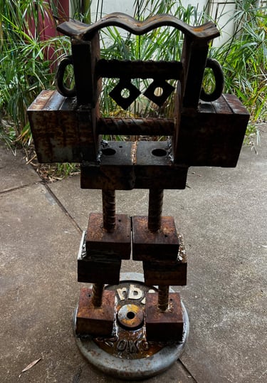 Rustic industrial metal robot sculpture made from salvaged iron and weight plates.