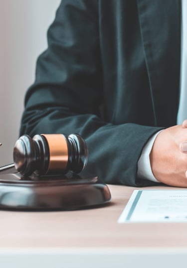 a judge's hand holding a gavel and a gavel