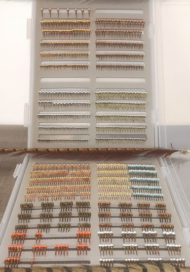fly fishing box filled with organized rows of tungsten beadhead nymphs and midges.
