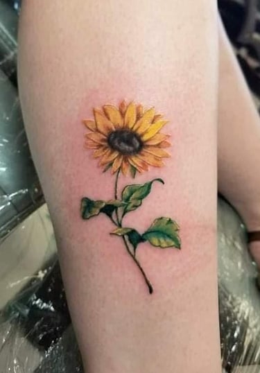 a sunflower tattoo on the leg of a woman's leg