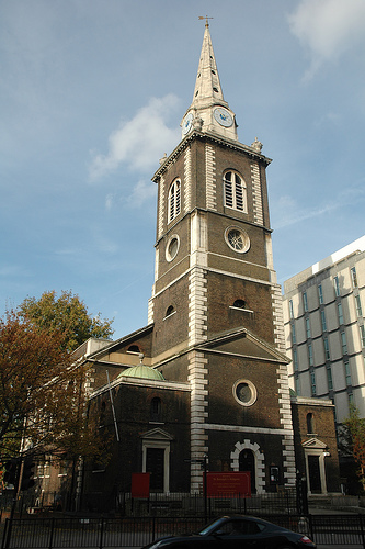 a church with a steeple tower in the background made from bricks and natural portland stone