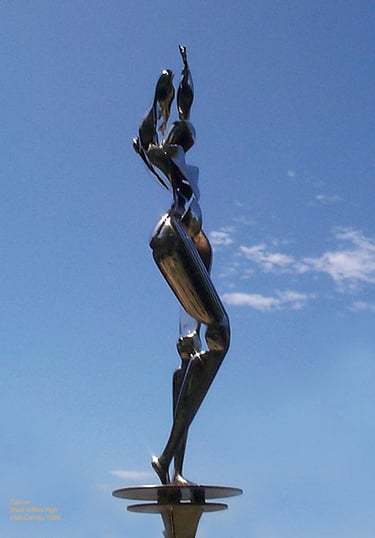 a chrome plated steel sculpture of a futuristic woman dancing on a pedestal