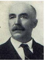 black and white  headshot of a man with a mustache and white hair