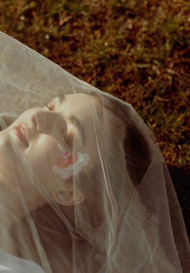 portrait rapproché d'un visage féminin maquillé recouvert d'un voile en tulle transparent