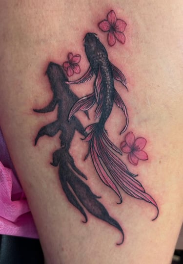 a tattoo of a coi fish and a woman's legs