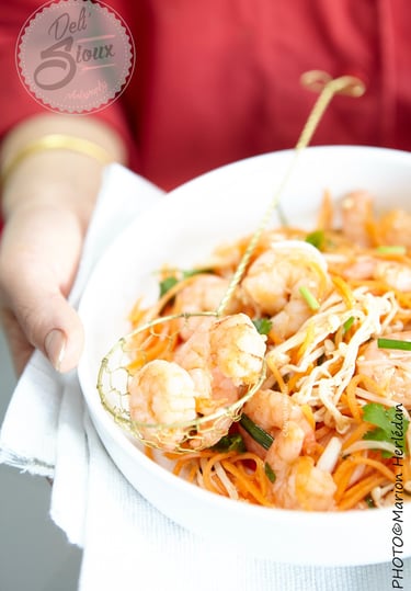 pad thaï de crevette dans un bol blanc tenu pas deux mains en gros plan