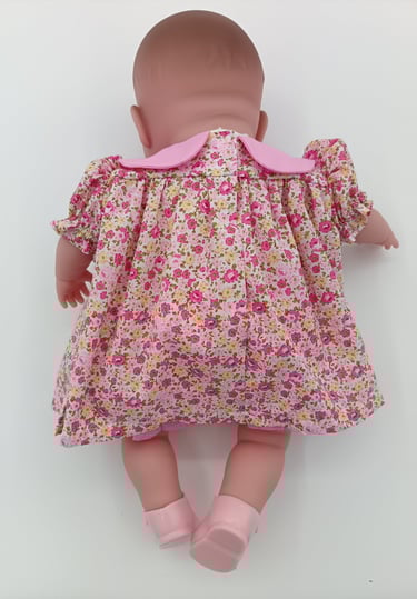 Back view of pink floral dress on Berenguer twin