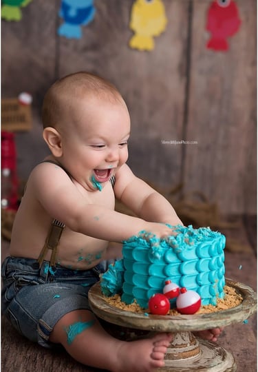Cute baby enjoying after smashing a birthday cake, creating a perfect memory.
