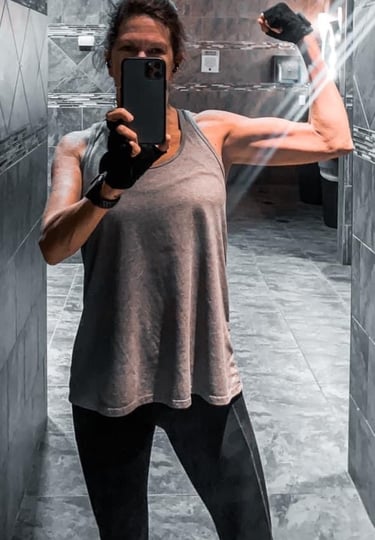 a woman taking a selfie in a mirror in a bathroom