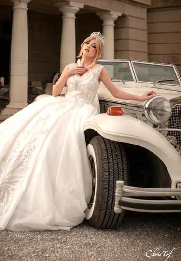 photo d'une mariées en robe de mariée devant une voiture retro au chateau de valmy 66 