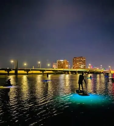 Atmospheric night kayaking and paddleboarding tour in Florida, paddling through calm waters with glo