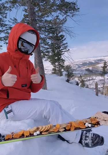 Close-up of clear containers filled with strawberries, blueberries, cubes of cheese, and prosciutto 